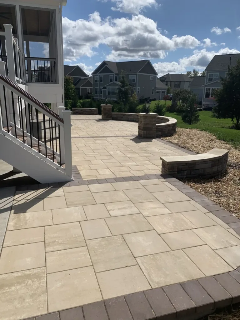 Beautiful travertine patio installation with brick sitting walls.