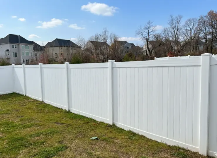 White vinyl privacy fence installed in a residential backyard providing security and clean modern curb appeal
